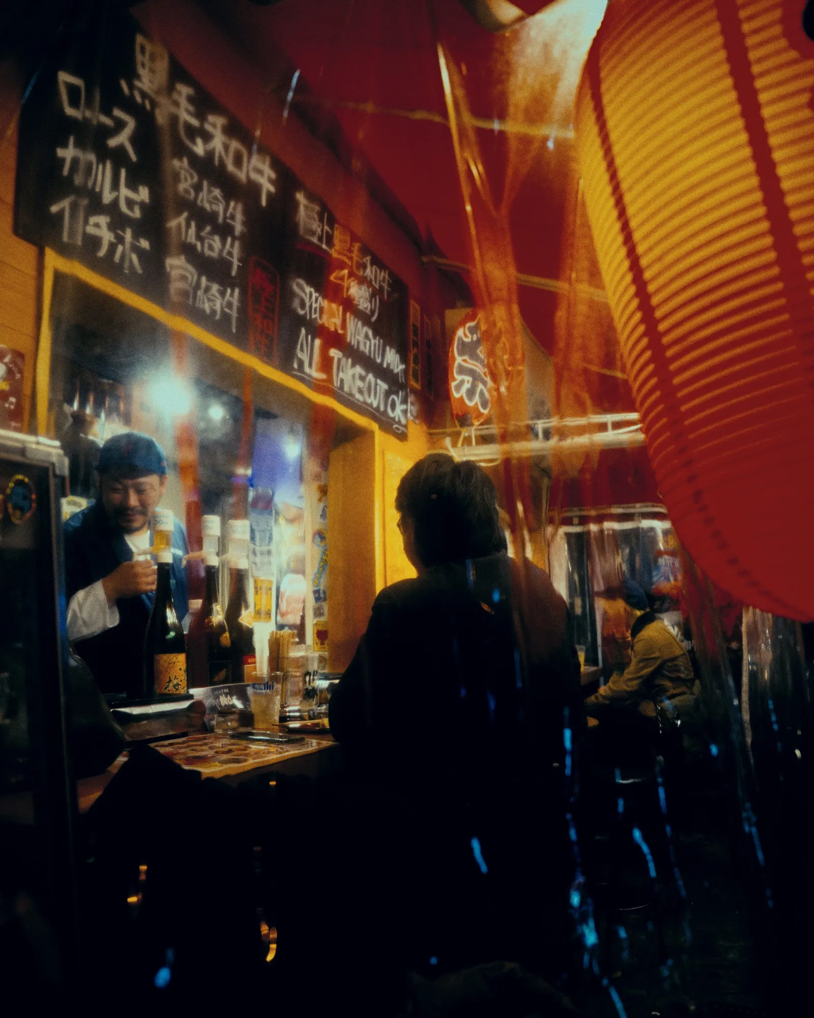 夜の屋台で客に料理を出す店主